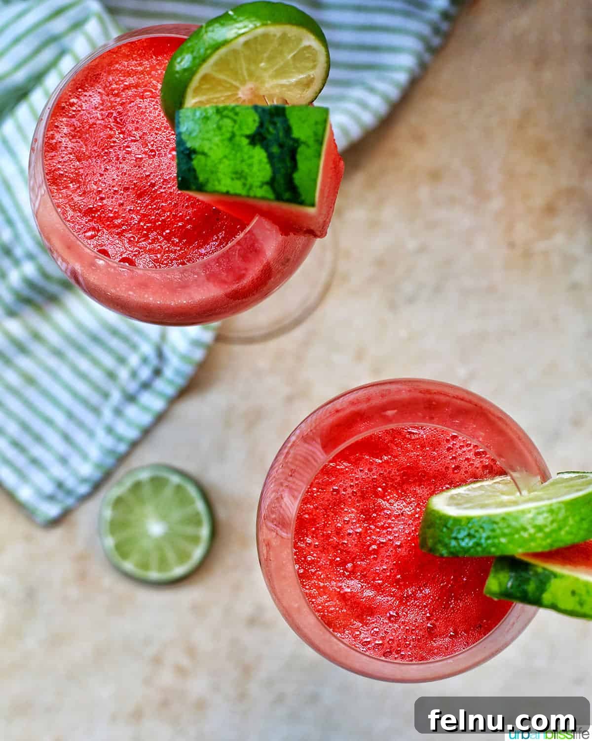 Watermelon Sunset Fizz 3 An overhead view of two elegant glasses of Watermelon Mimosas, each beautifully garnished with fresh watermelon and lime slices, inviting a refreshing taste.