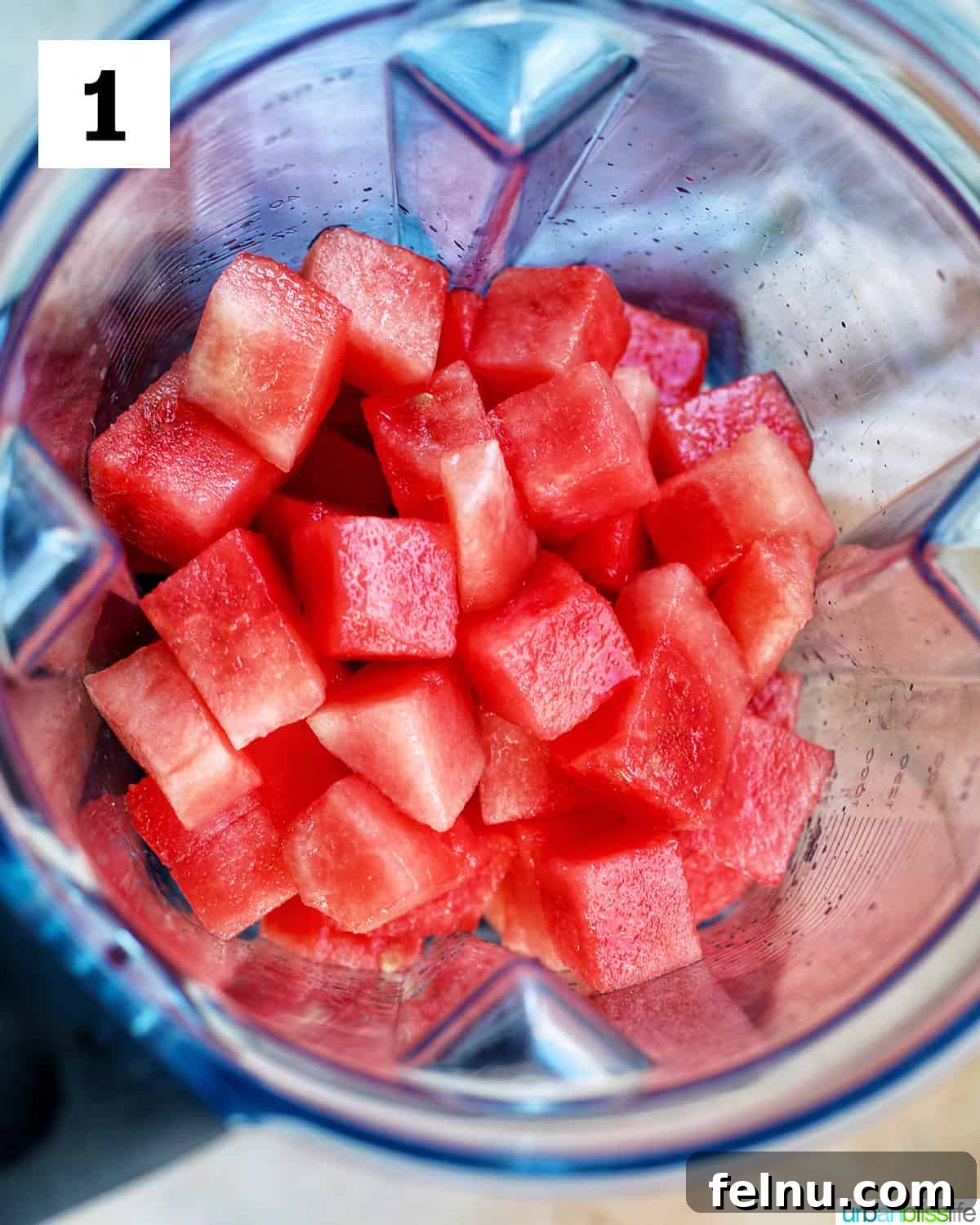 Watermelon Sunset Fizz 5 Cubed seedless watermelon being placed into a blender, ready for pureeing to create a refreshing watermelon mimosa base.