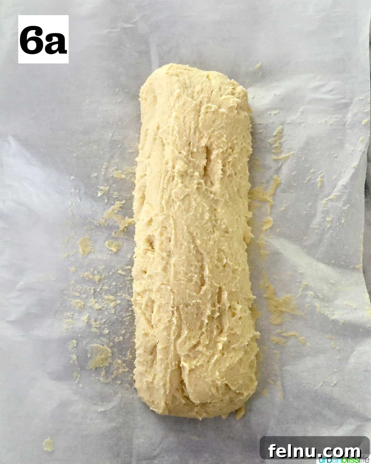 Tangy Key Lime Delights 14 Key lime cookie dough shaped into a uniform log and placed on parchment paper, ready for chilling.
