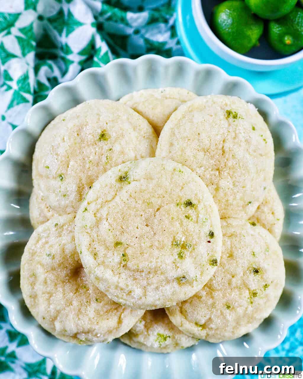 Tangy Key Lime Delights 19 A stack of golden key lime cookies artfully arranged on a plate, accompanied by fresh key limes, ready to be served.