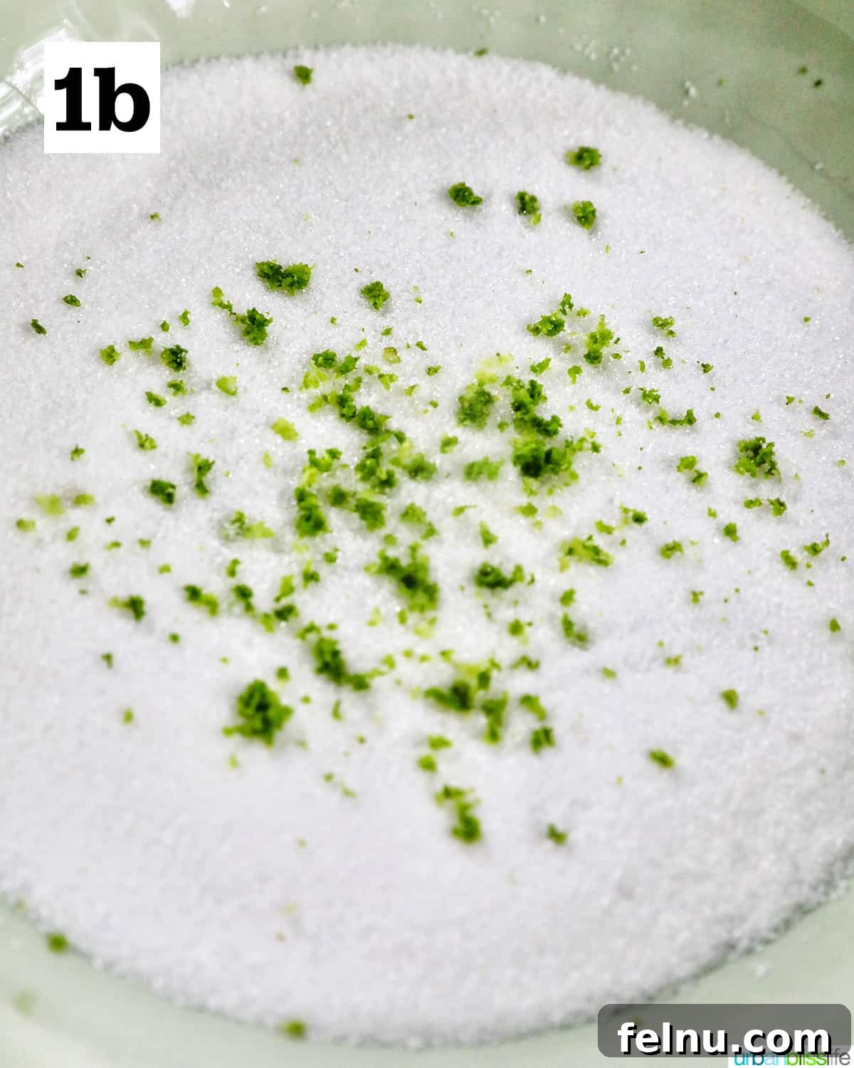 Tangy Key Lime Delights 7 A close-up view of a bowl containing granulated sugar thoroughly mixed with finely grated key lime zest, ready for coating.