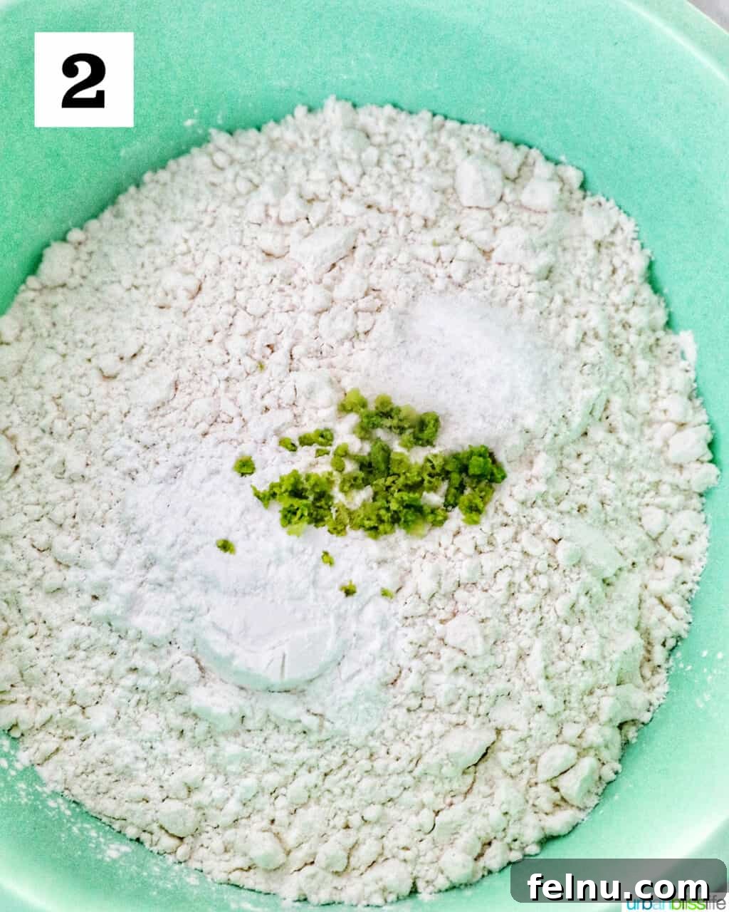 Tangy Key Lime Delights 8 A vibrant green mixing bowl filled with dry ingredients including flour, baking powder, salt, and the remaining key lime zest, ready to be whisked.