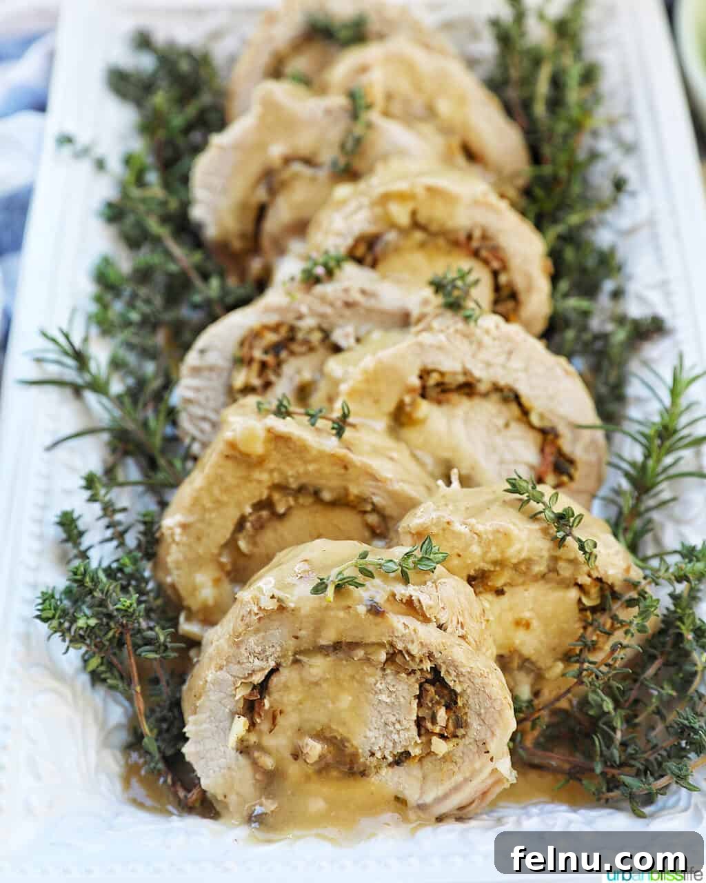 Instant Pot Pork Loin: A Flavorful One-Pot Wonder 2 Sliced stuffed pork loin on a white plate with herbs