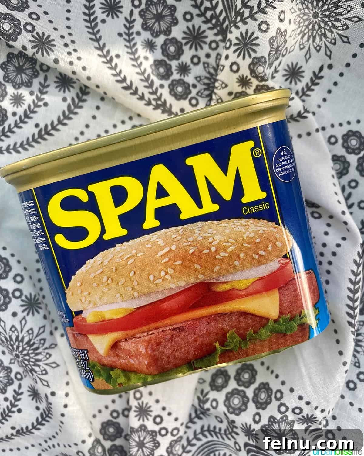 Building Your Essential Filipino Pantry 16 can of SPAM on a white and grey floral tablecloth.