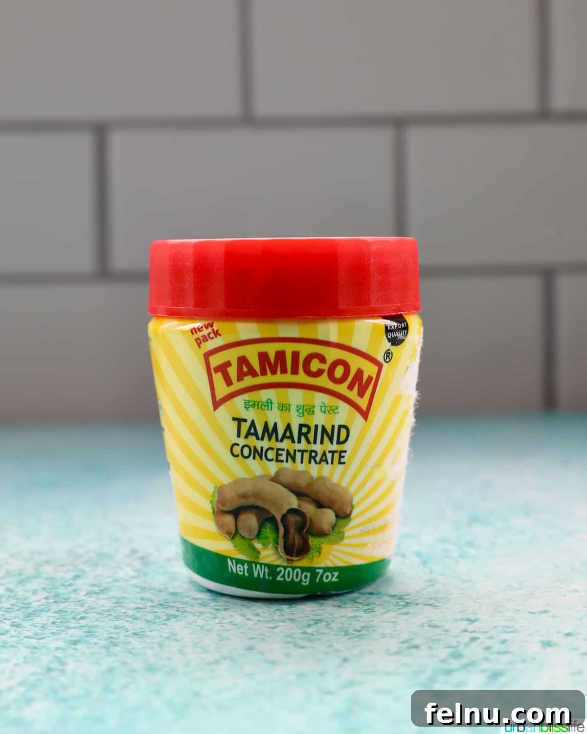 Building Your Essential Filipino Pantry 17 jar of tamarind paste on a blue table with white tile background.