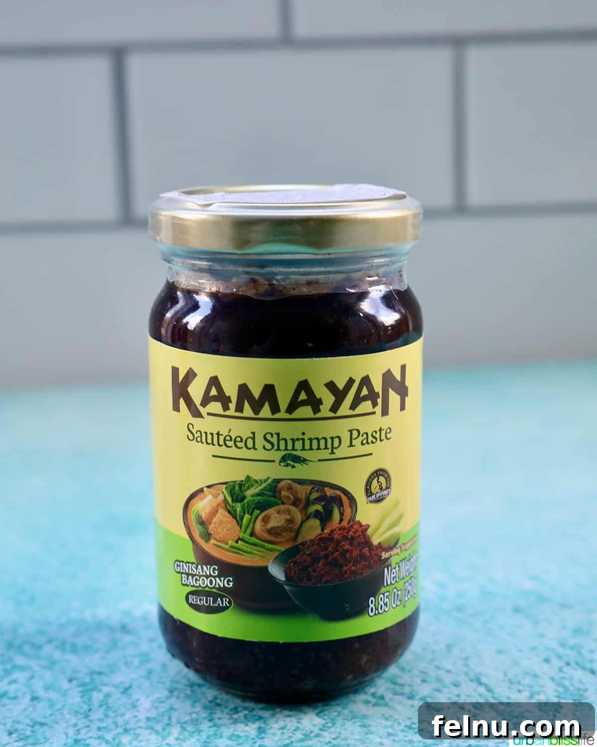 Building Your Essential Filipino Pantry 5 bottle of Kamayan shrimp paste (bagoong) on a blue table with white tile background.