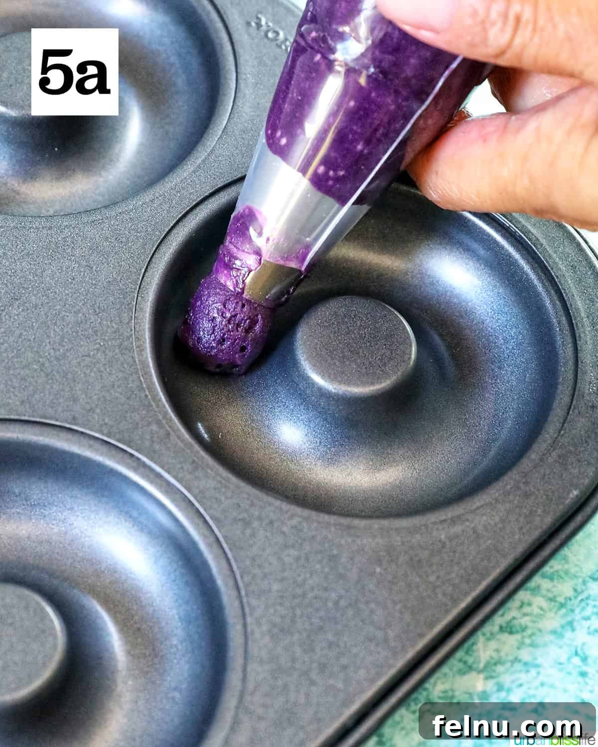 Ube Dream Donuts 11 Purple ube batter in a piping bag into a donut pan.