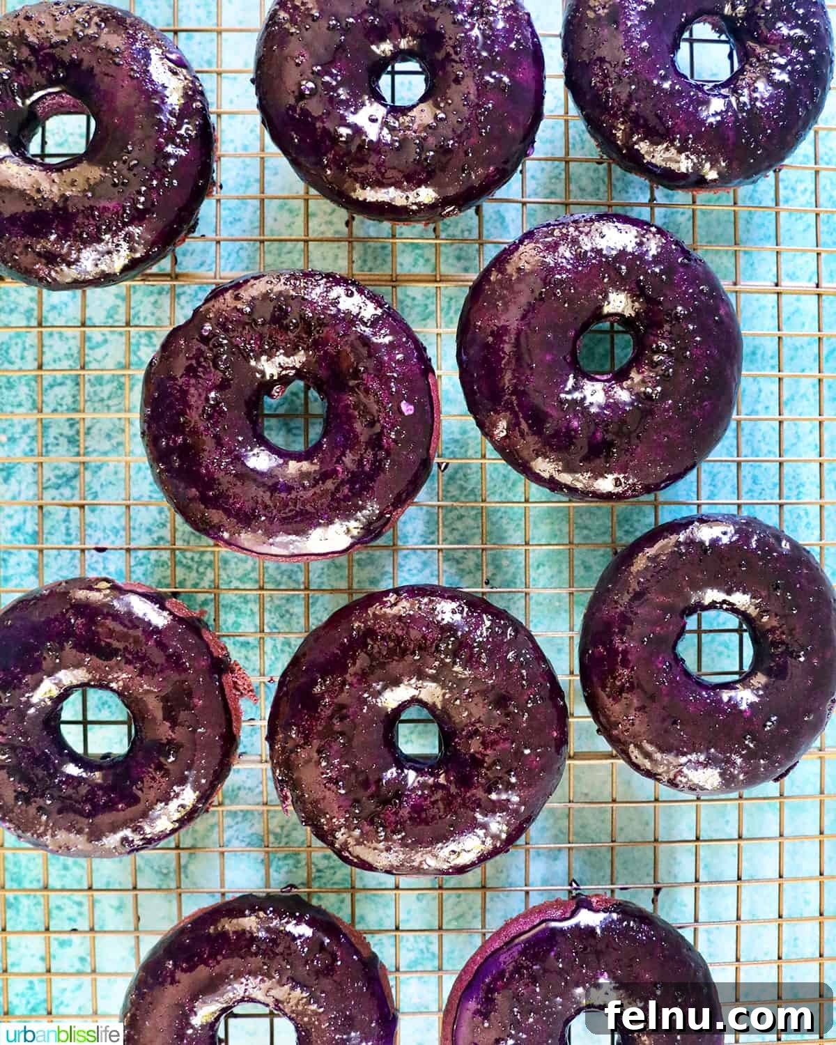 Ube Dream Donuts 3 A collection of vibrant purple ube donuts elegantly arranged on a cooling rack.