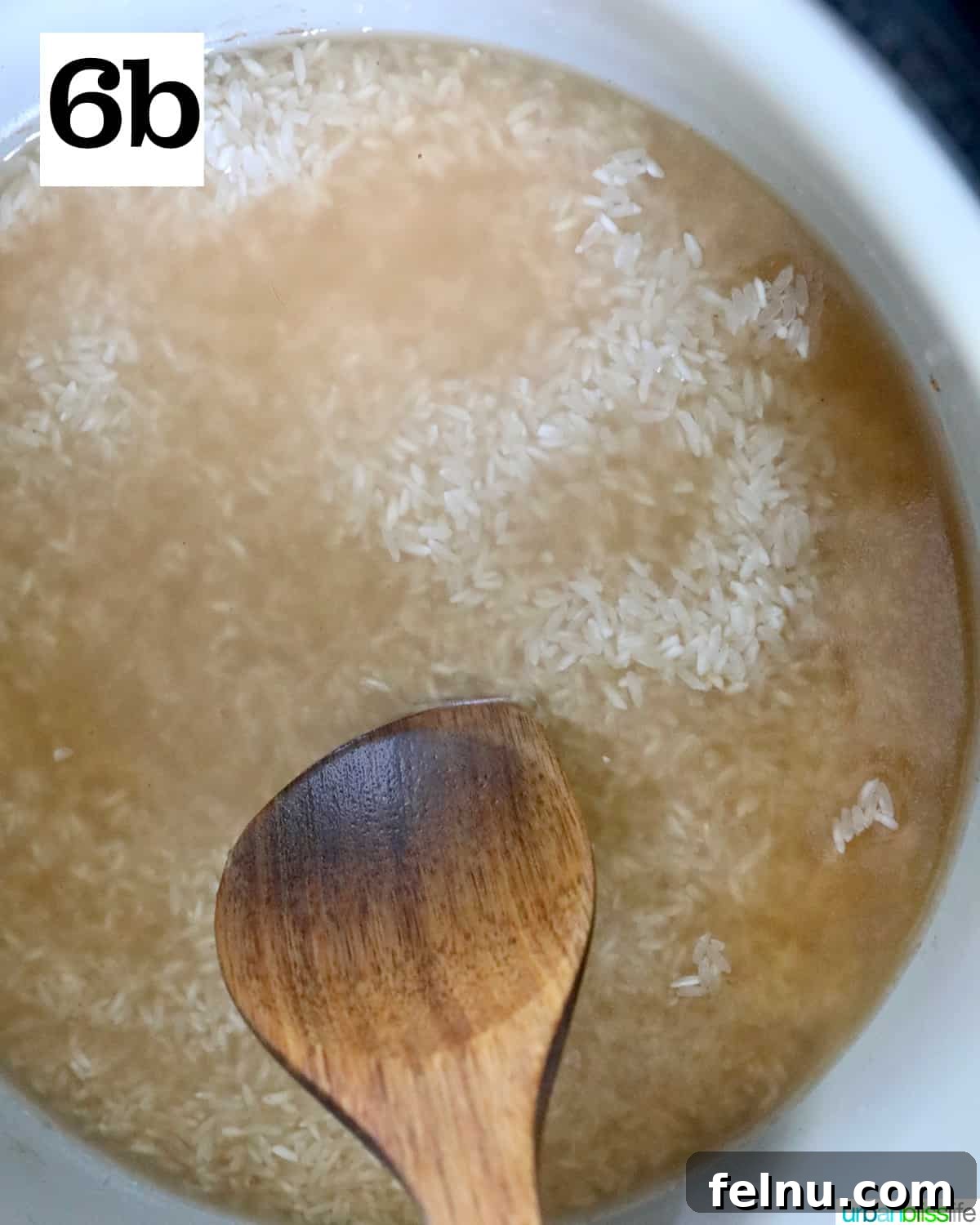 Instant Pot Pork Chop Rice Bowl 11 Gently pushing rice into broth with a wooden spoon inside an Instant Pot.