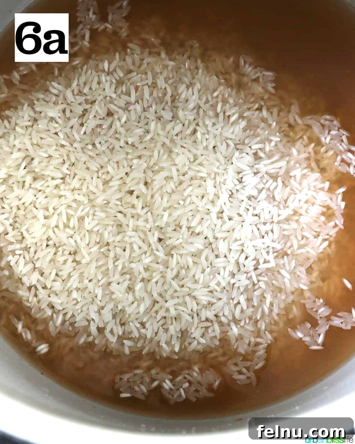 Instant Pot Pork Chop Rice Bowl 10 Rice added to broth inside a Ninja Foodi pressure cooker or Instant Pot.