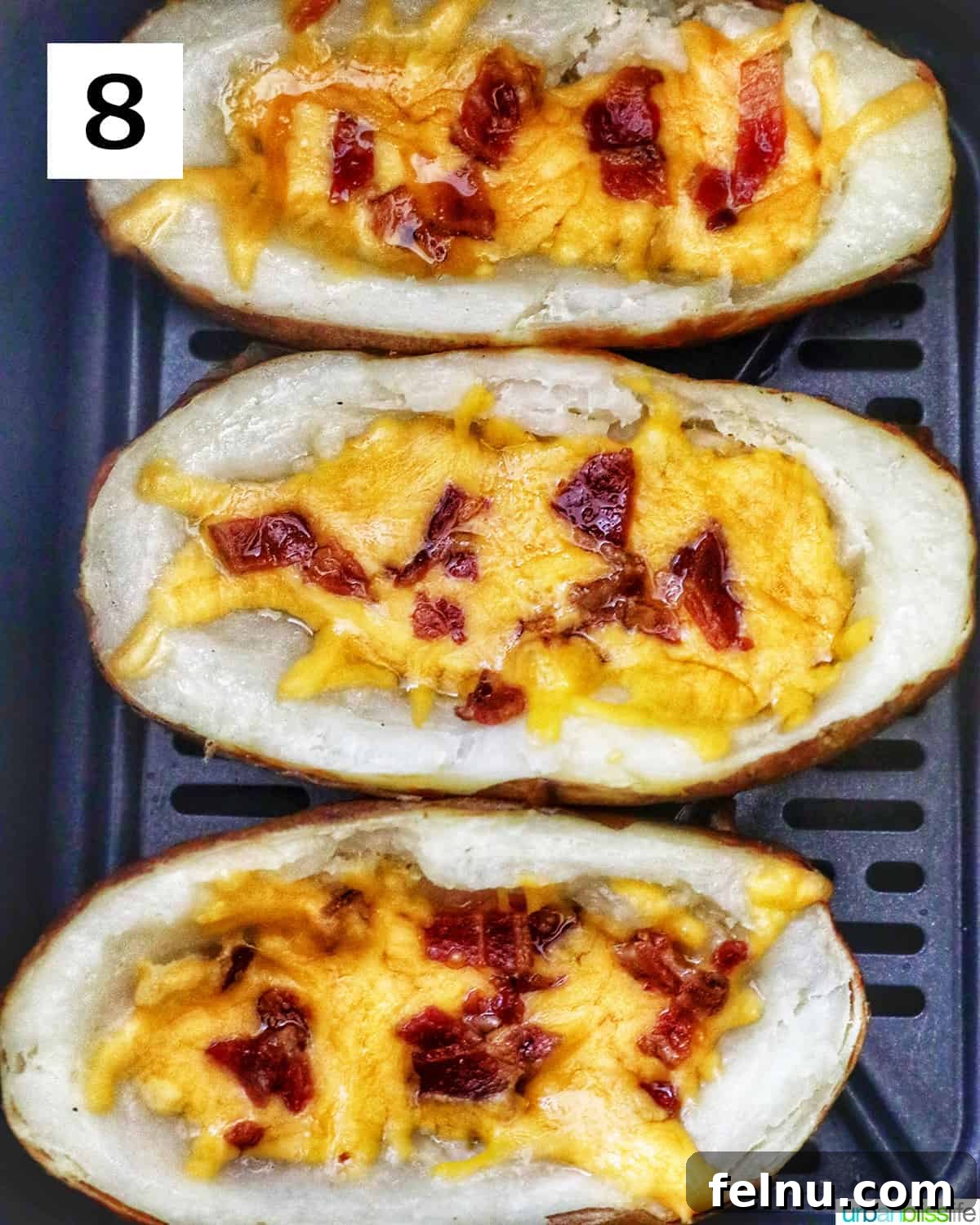 Ultimate Air Fryer Potato Skins 13 baked potato skins with bacon and melted cheese in an air fryer.