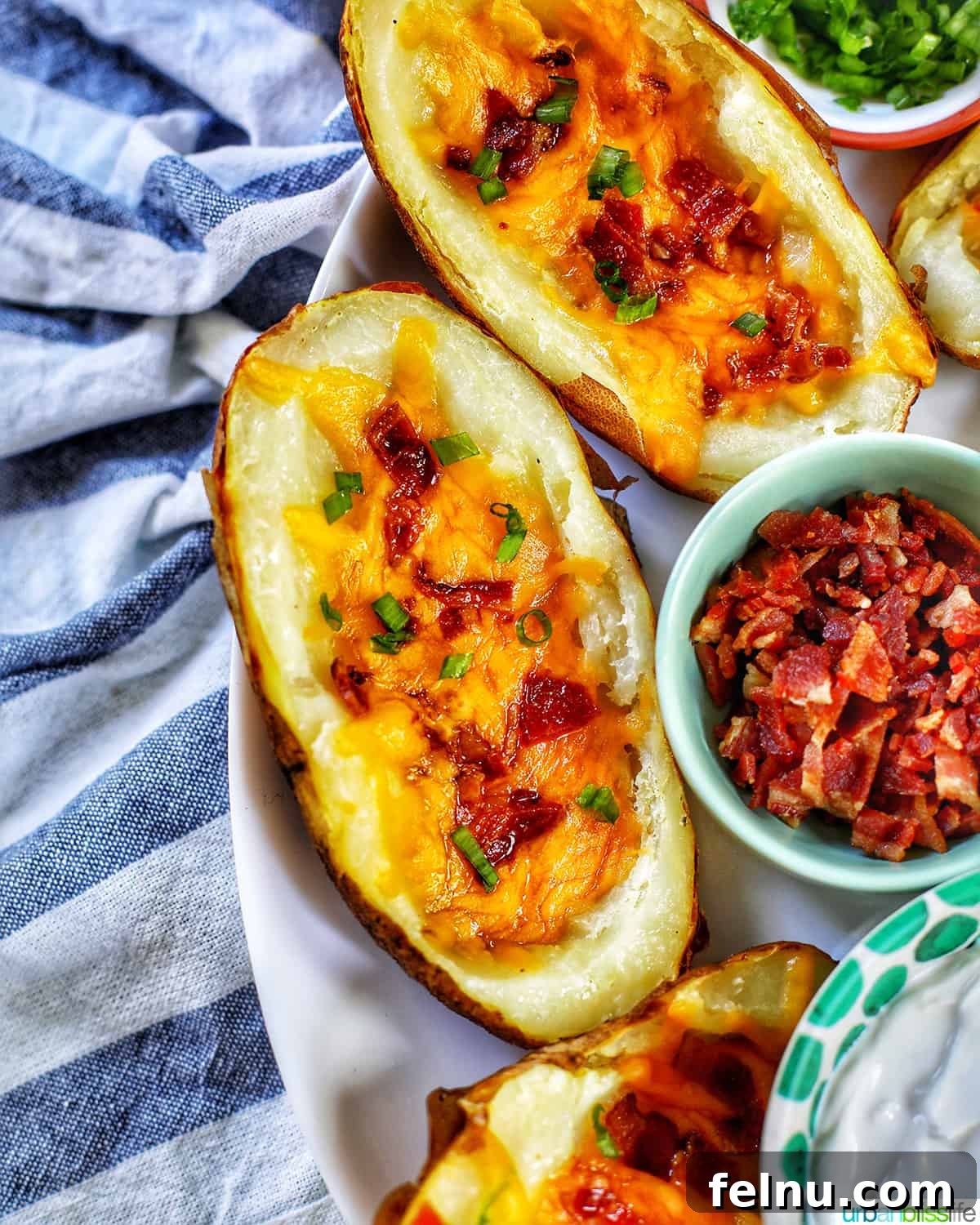 Ultimate Air Fryer Potato Skins 3 several air fryer potato skins with sides of green onions, bacon, and sour cream.