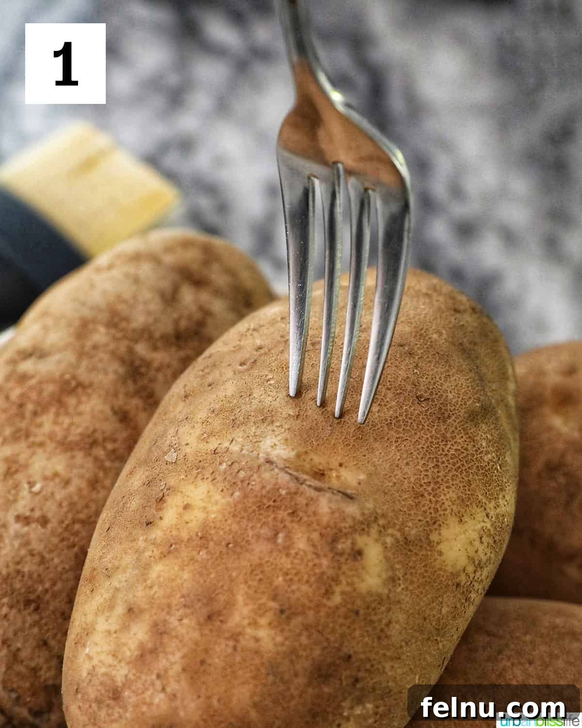 Ultimate Air Fryer Potato Skins 5 a fork piercing the center of a baking potato.