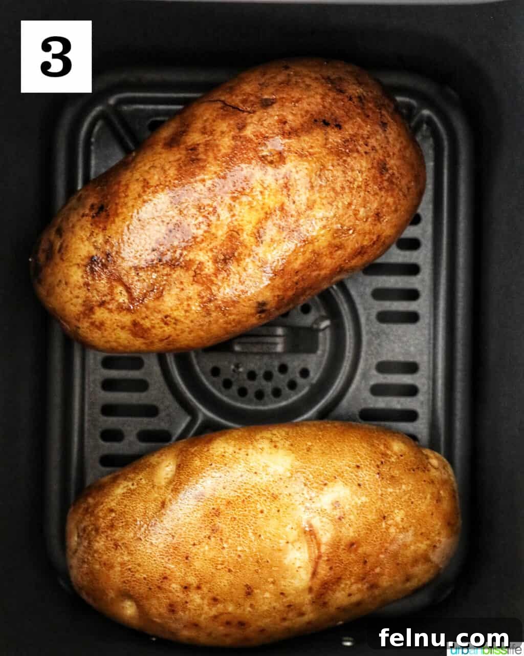 Ultimate Air Fryer Potato Skins 7 two potatoes in an air fryer basket.