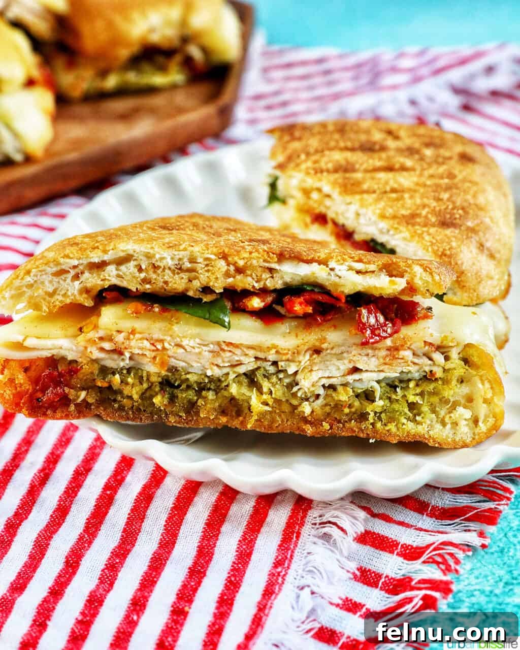 Delicious Turkey Pesto Sandwich cut in half on a white plate