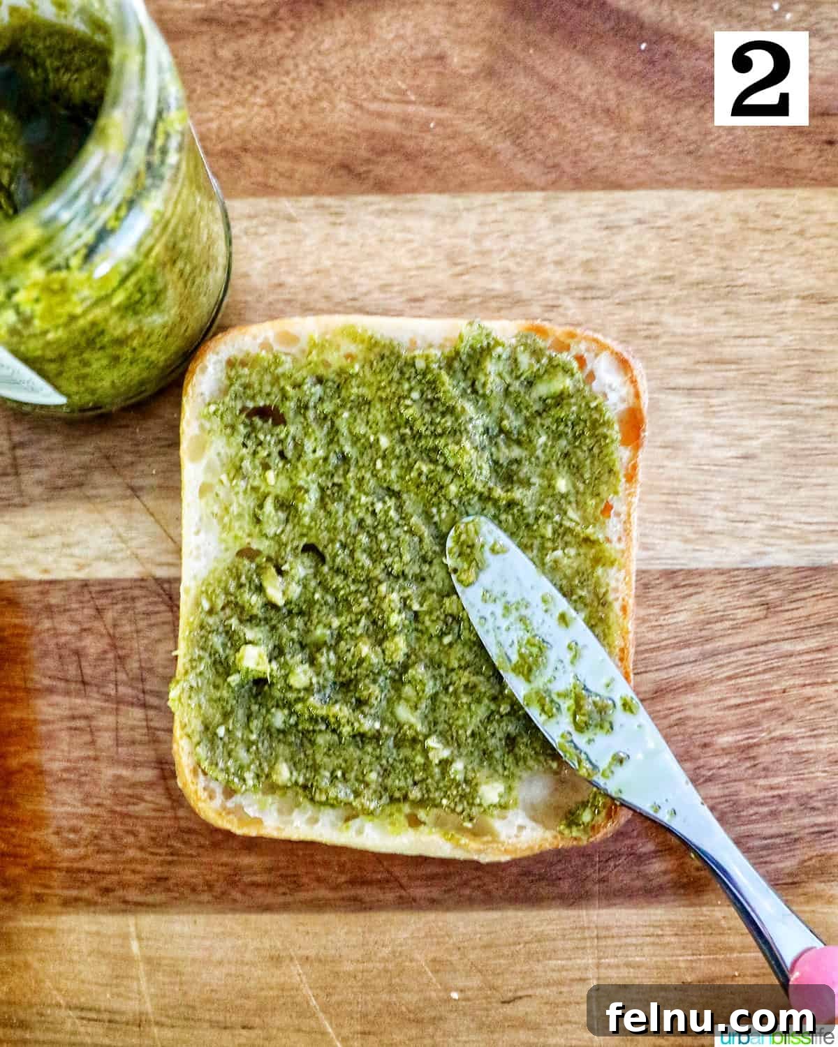Spreading pesto on ciabatta bread