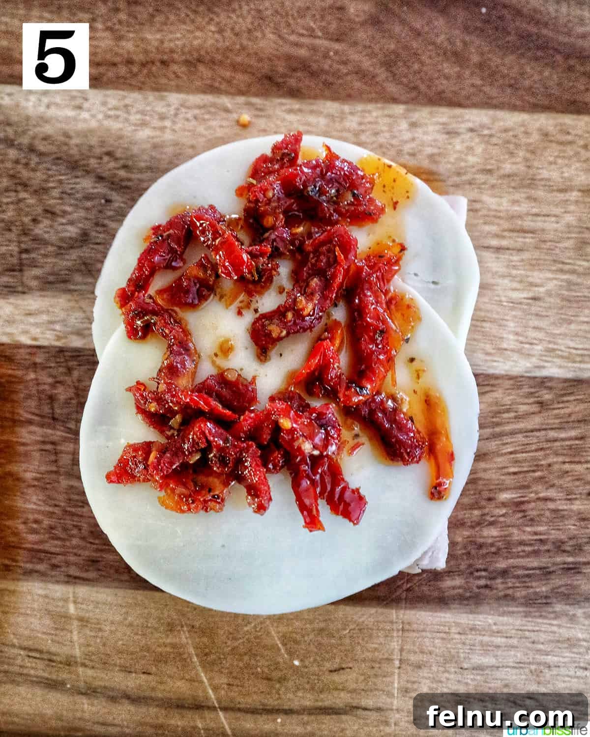 Adding sun-dried tomatoes to the provolone cheese
