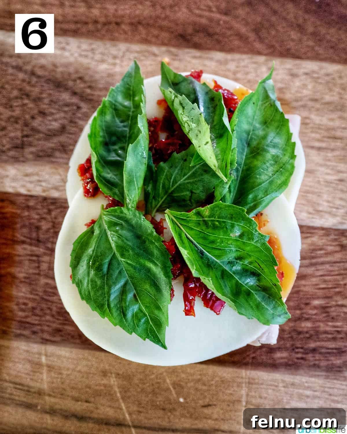 Adding fresh basil leaves to the sun-dried tomatoes