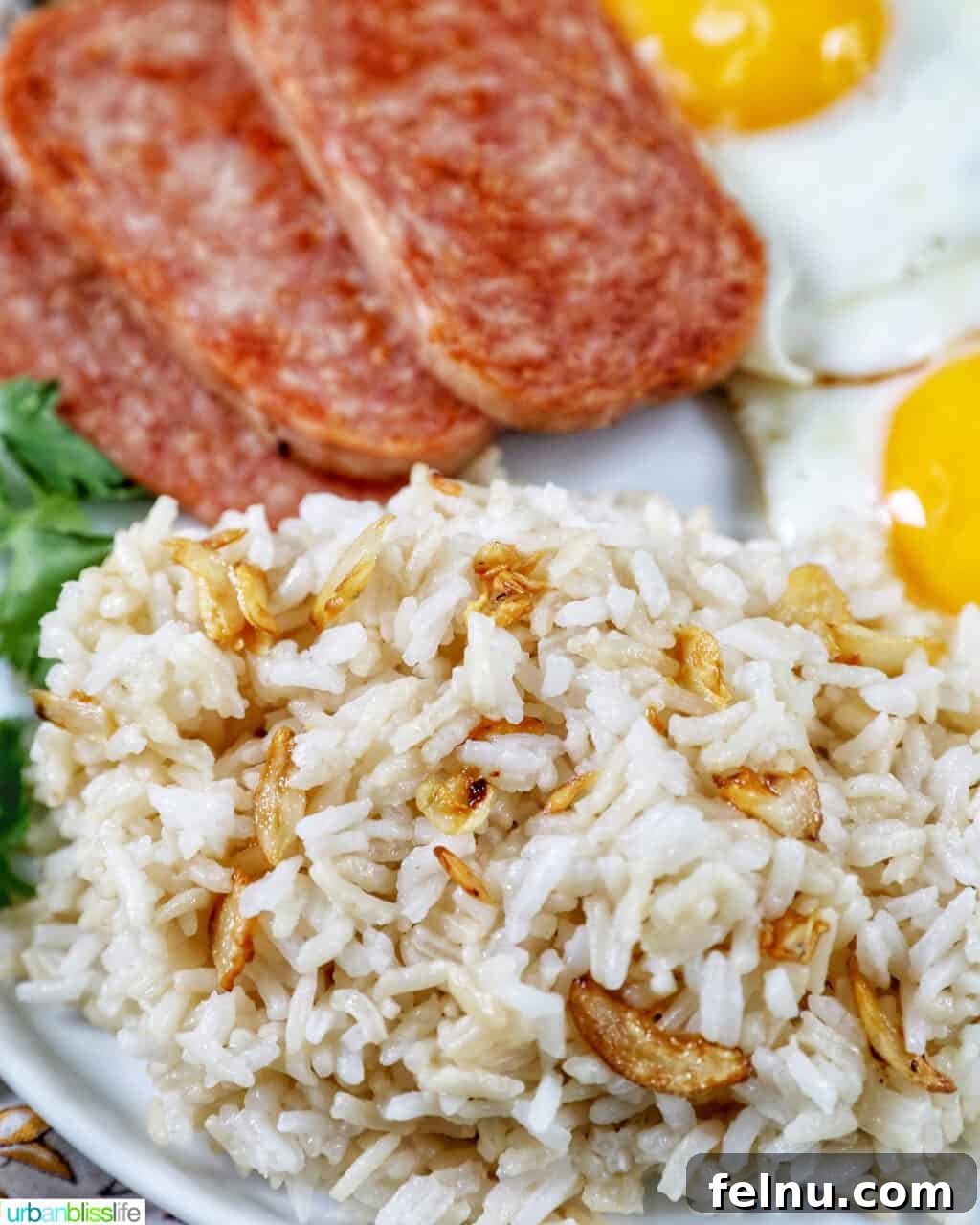 Spamsilog A Filipino Breakfast Classic 9 Plate of Spamsilog: slices of Spam, two eggs over easy, and Filipino Sinangag garlic rice with greens.