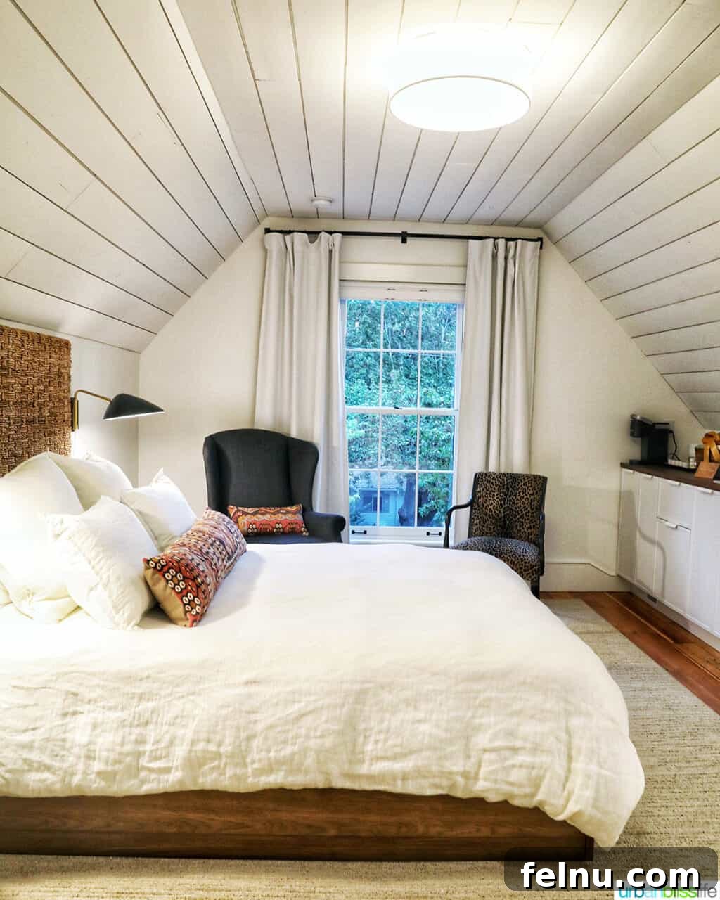 A side view of the bed, chairs, and kitchenette within Kubli Haus Suite 3 in Jacksonville, Oregon.