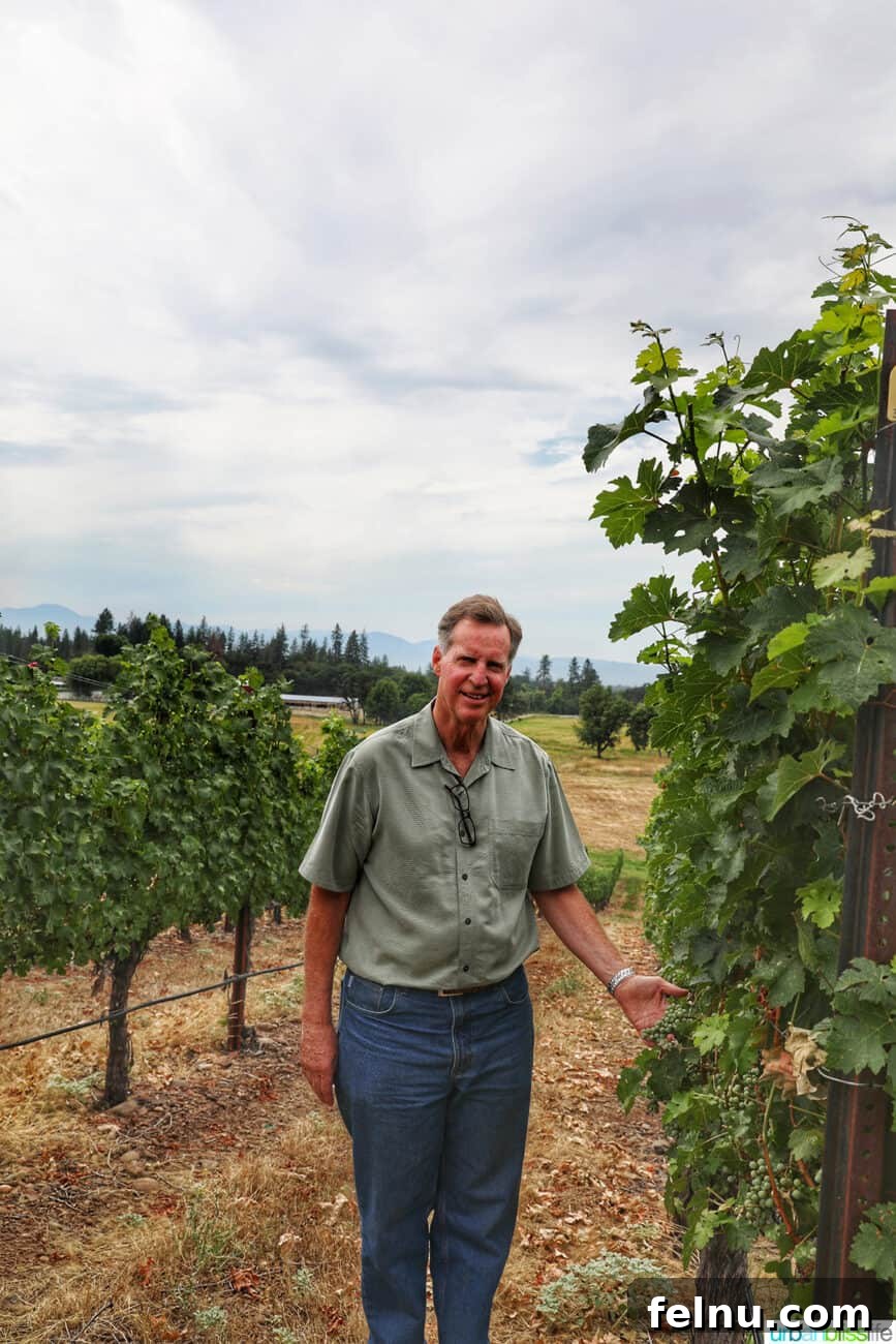 Kriselle Cellars Oregon Wine Country Gem 4 Scott Steingraber, owner and winemaker of Kriselle Cellars, stands proudly amidst his flourishing vineyard, embodying the passion and dedication behind Southern Oregon's acclaimed wines.