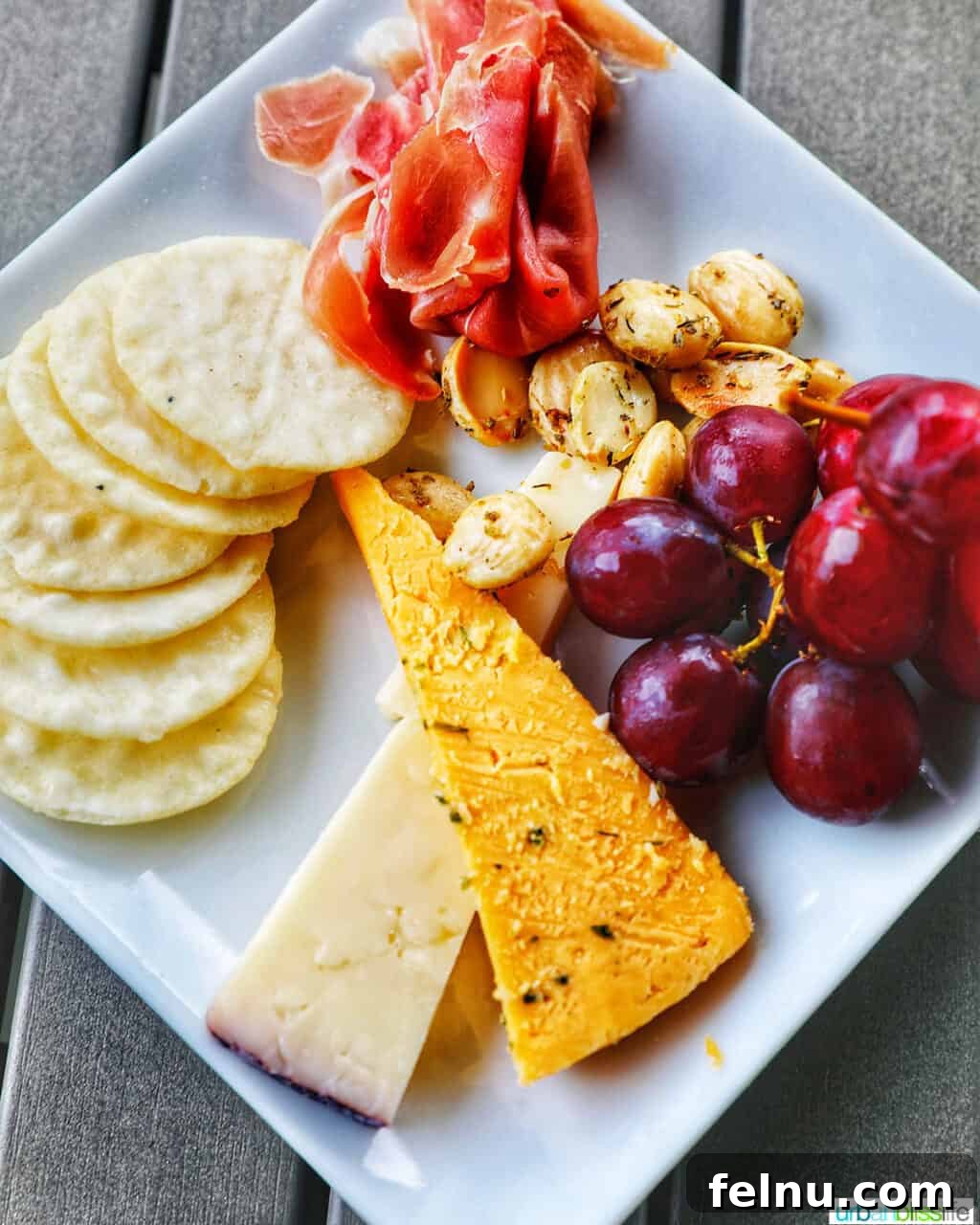 Kriselle Cellars Oregon Wine Country Gem 9 An exquisite cheese and fruit plate, featuring artisanal cheeses, crisp crackers, savory prosciutto, fresh grapes, and crunchy nuts, perfectly complementing a wine tasting experience at Kriselle Cellars.
