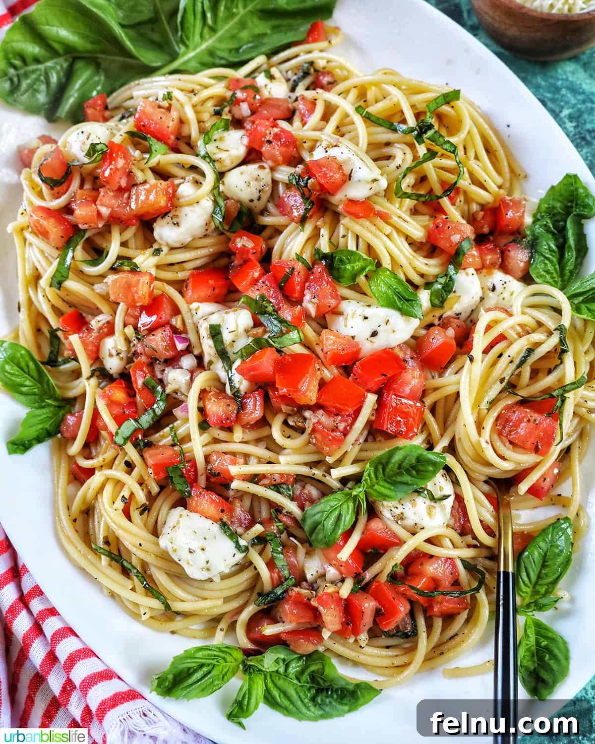 Bruschetta pasta with tomatoes, mozzarella, and basil in a large serving platter.