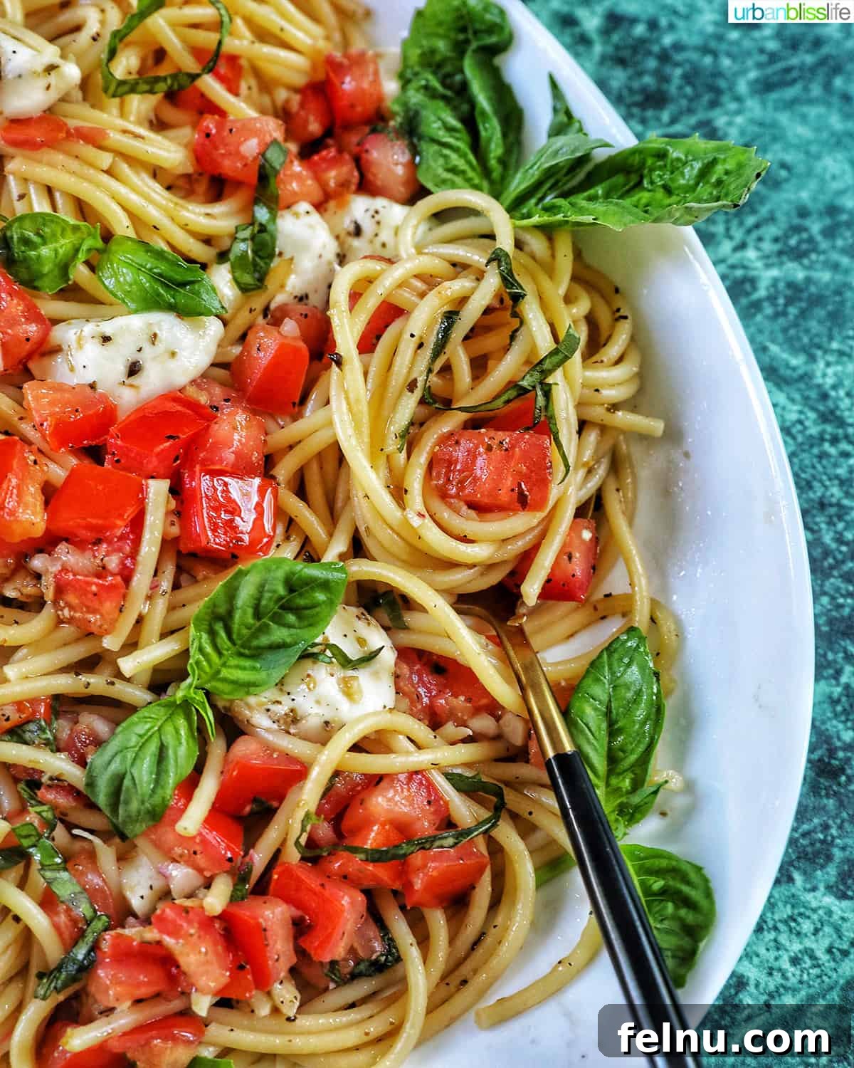 Bruschetta pasta with tomatoes, basil, and mozzarella cheese in a big serving bowl.