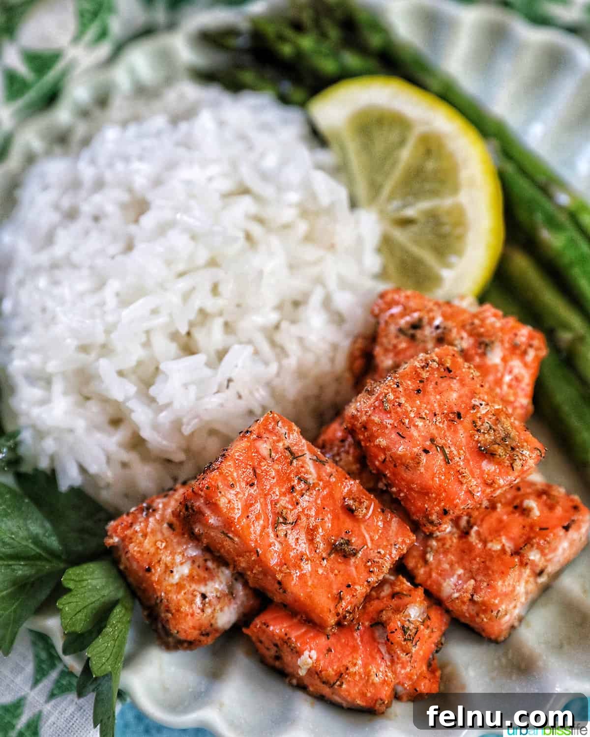 Golden Crispy Salmon Bites 2 air fryer salmon bites with white rice, asparagus, and lemon slice.