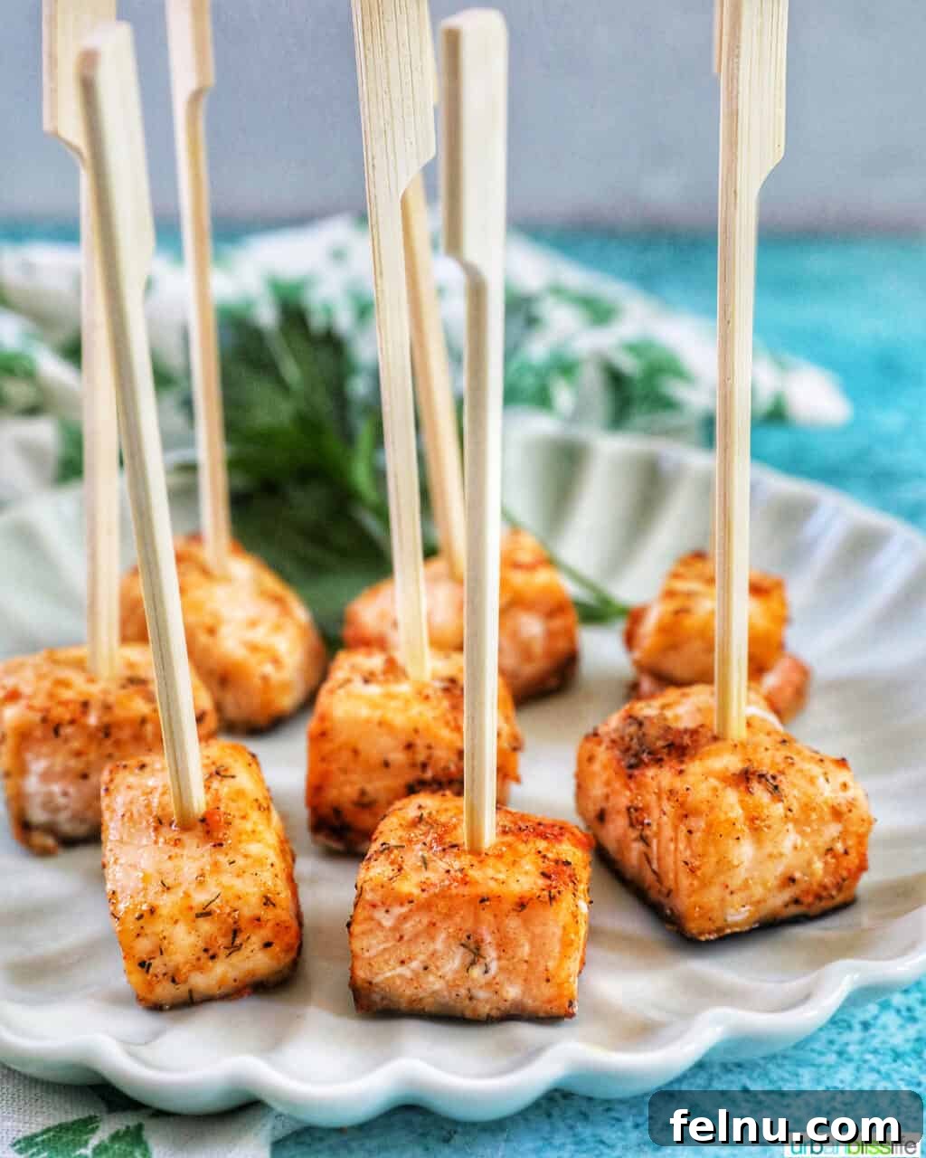 Golden Crispy Salmon Bites 8 air fryer salmon bites served as appetizers on a plate.