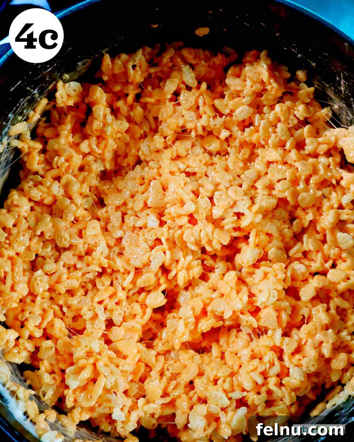 Seasonal Pumpkin Crunch Squares 11 The fully mixed orange Rice Krispies cereal and marshmallow mixture in a Dutch oven.