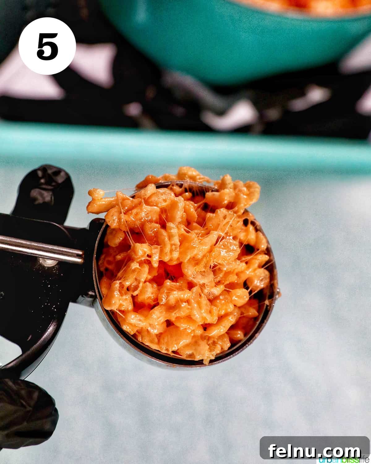 Seasonal Pumpkin Crunch Squares 12 A large scoop of orange pumpkin rice krispie treats mixture.