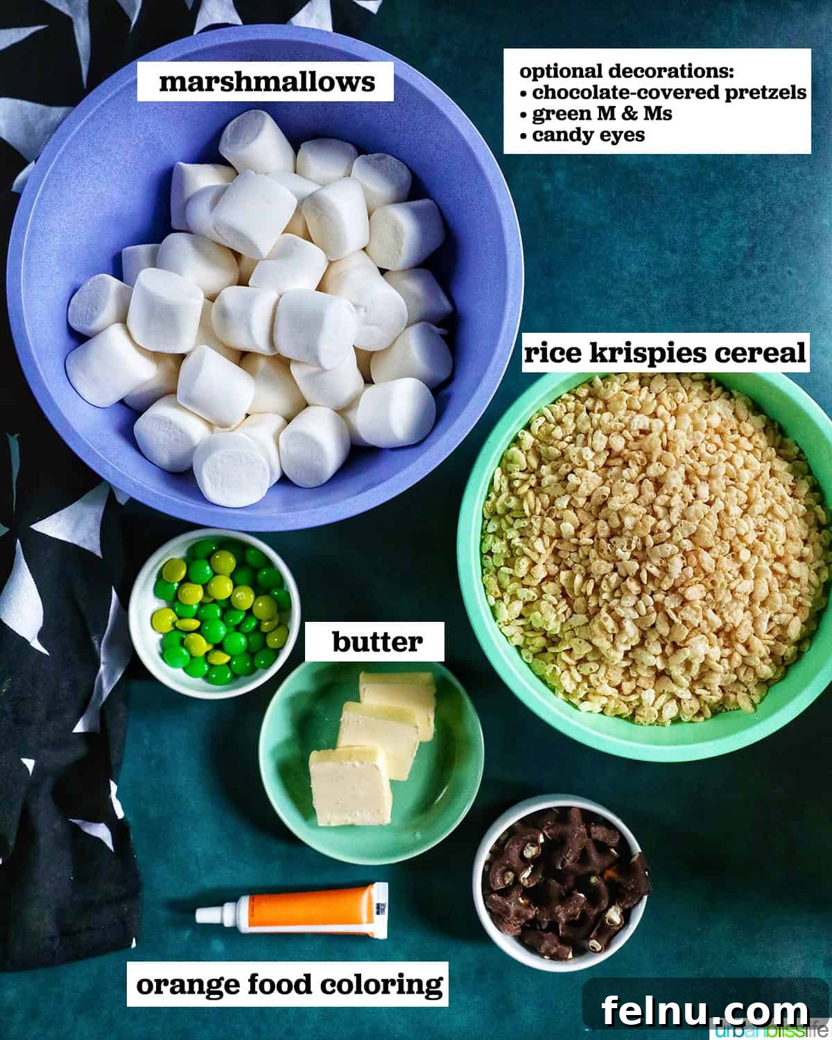 Seasonal Pumpkin Crunch Squares 4 Key ingredients for pumpkin rice krispie treats: marshmallows, rice krispies cereal, orange food coloring, and various decorations like pretzels and candy eyeballs.