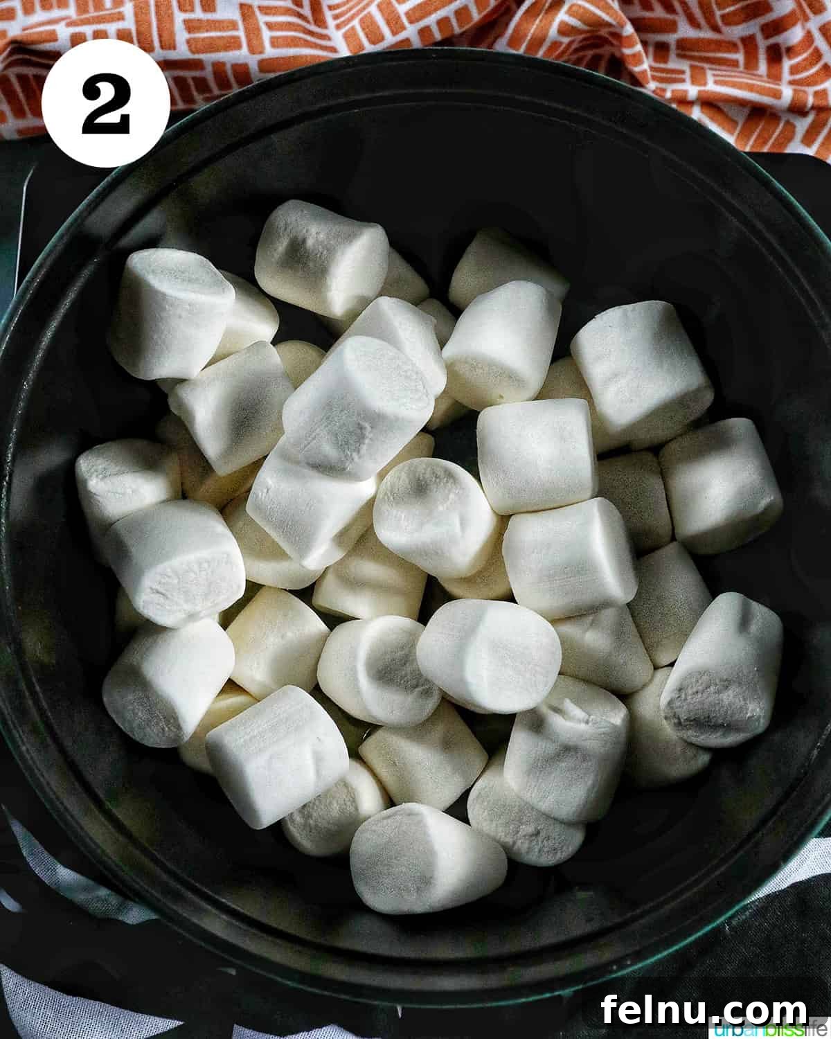 Seasonal Pumpkin Crunch Squares 6 Marshmallows being added to melted butter in a Dutch oven.