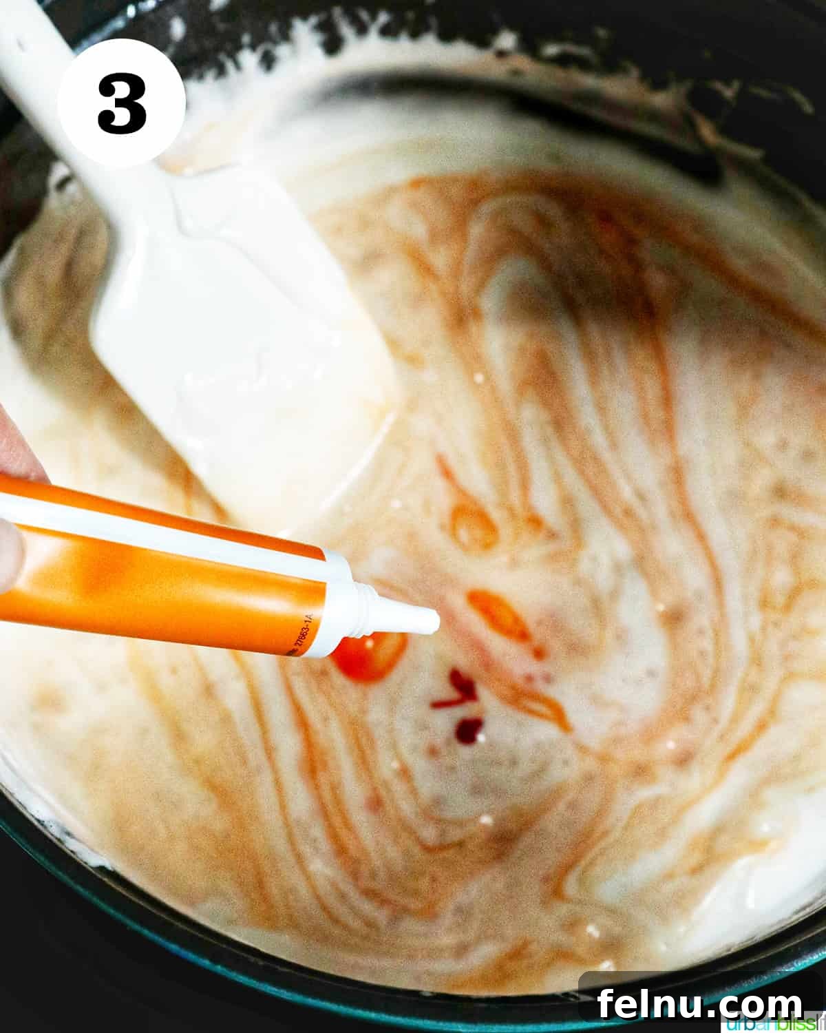 Seasonal Pumpkin Crunch Squares 7 Orange food coloring being added to the melting marshmallow mixture in a Dutch oven.
