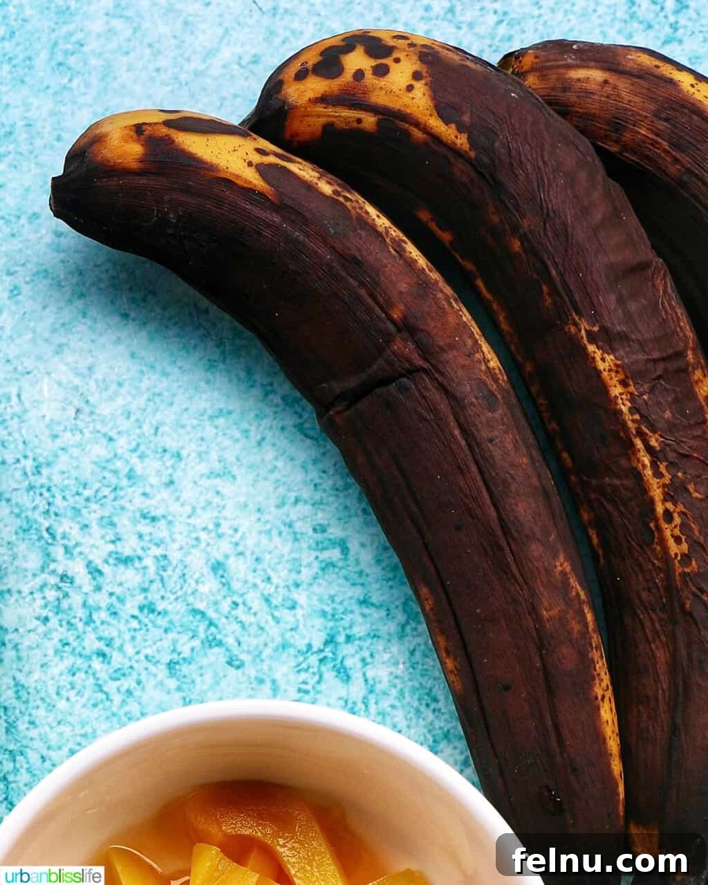 Creative Banana Bakes: Turning Overripe into Delicious 2 A cluster of overripe bananas on a bright blue table, perfect for baking.