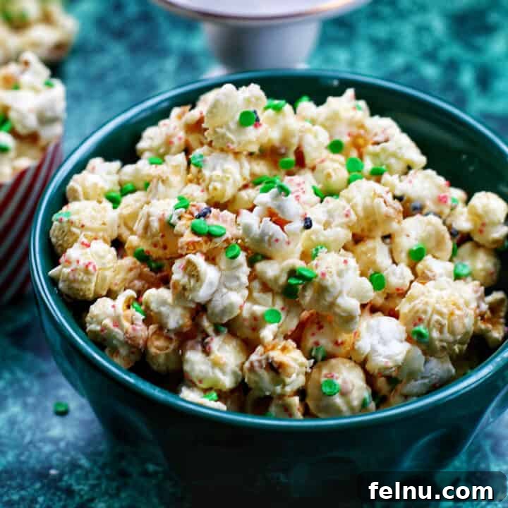 Christmas popcorn mix in a green bowl on a green table.