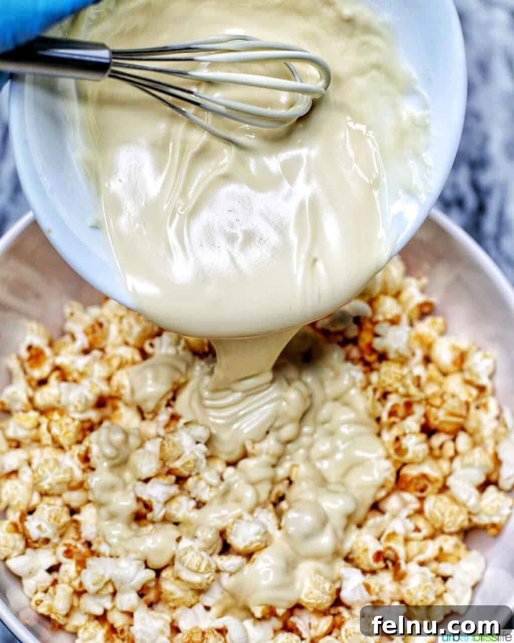 Festive Holiday Popcorn Mix 8 pouring melted white chocolate over popcorn