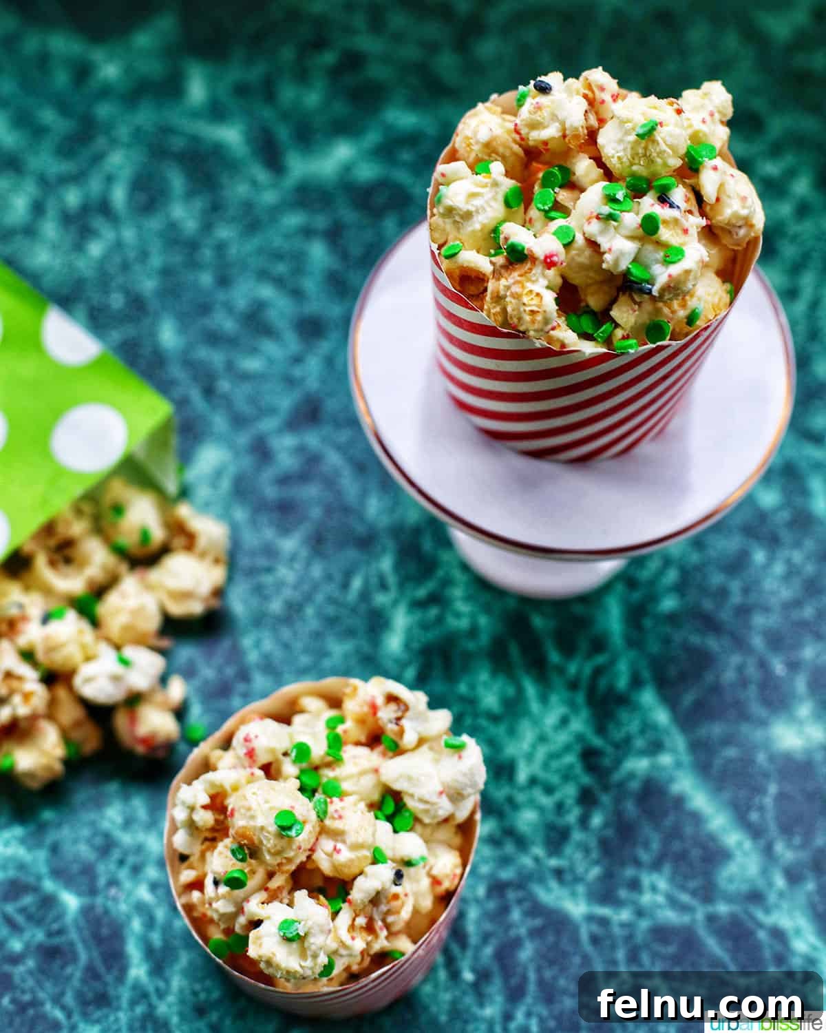 Festive Holiday Popcorn Mix 10 Christmas popcorn in bags and popcorn holders on a green table.