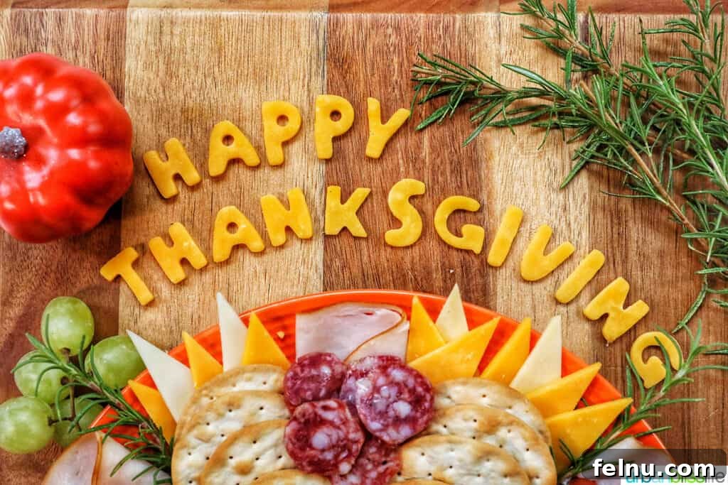 Cheese cut into letters stating Happy Thanksgiving at the top of a turkey charcuterie board.