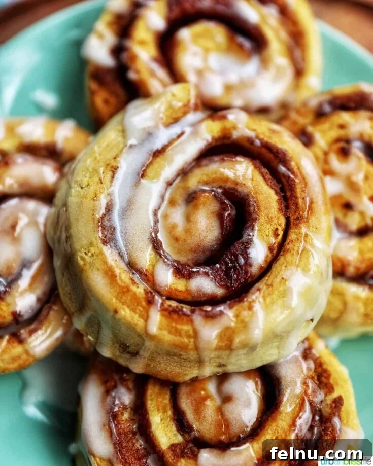 Perfectly cooked air fryer cinnamon rolls with a cream cheese frosting.