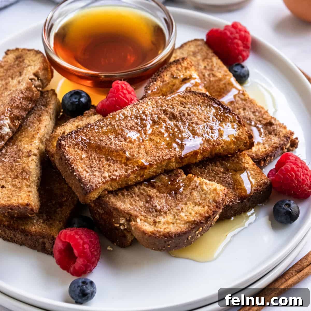 Crispy air fryer french toast sticks coated with cinnamon sugar.