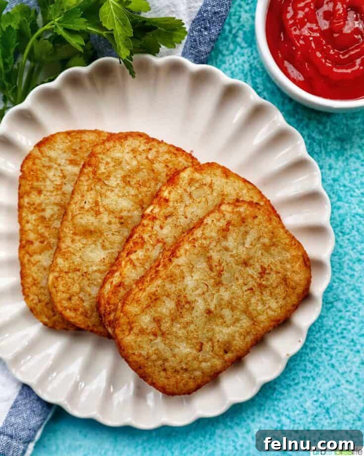 Hot and crispy air fryer hash brown patties on a white plate.