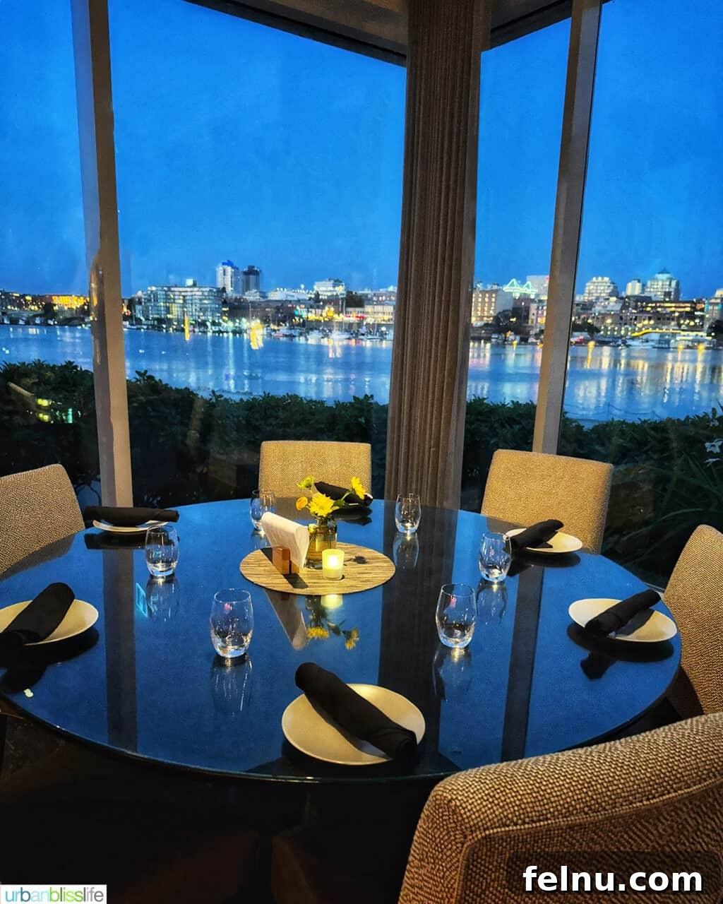 The Laurel Point Haven 10 round dinner table and chairs with a view of Victoria Harbour at Aura restaurant inside the Inn at Laurel Point hotel.