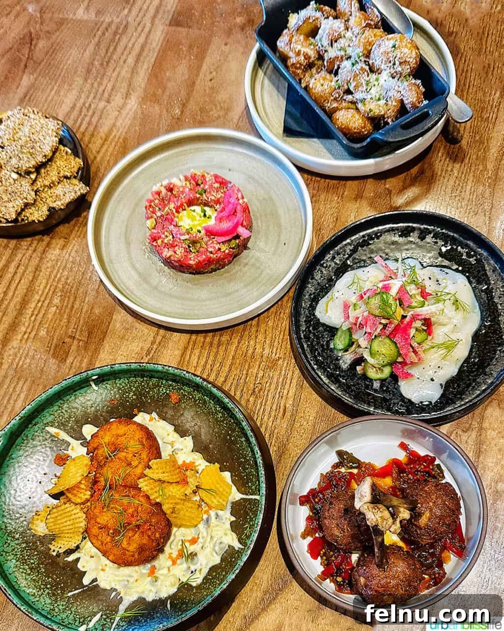 Banff Unleashed 2 Several dinner dishes on a table at Brazen Banff restaurant, showcasing colorful and artfully plated meals.