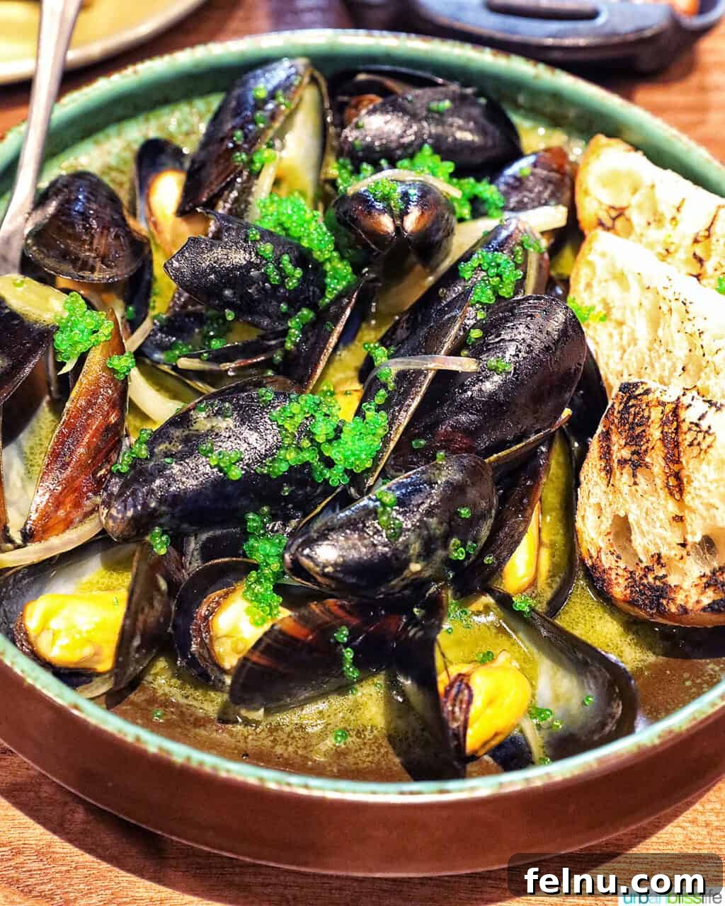 Banff Unleashed 11 Green tea mussels with bread in a bowl, featuring vibrant green tobiko.