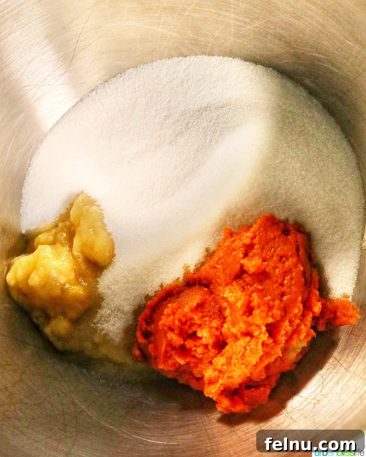 Pumpkin Banana Bliss Muffins 6 Pumpkin puree, mashed bananas, and sugar in a stand mixer bowl.