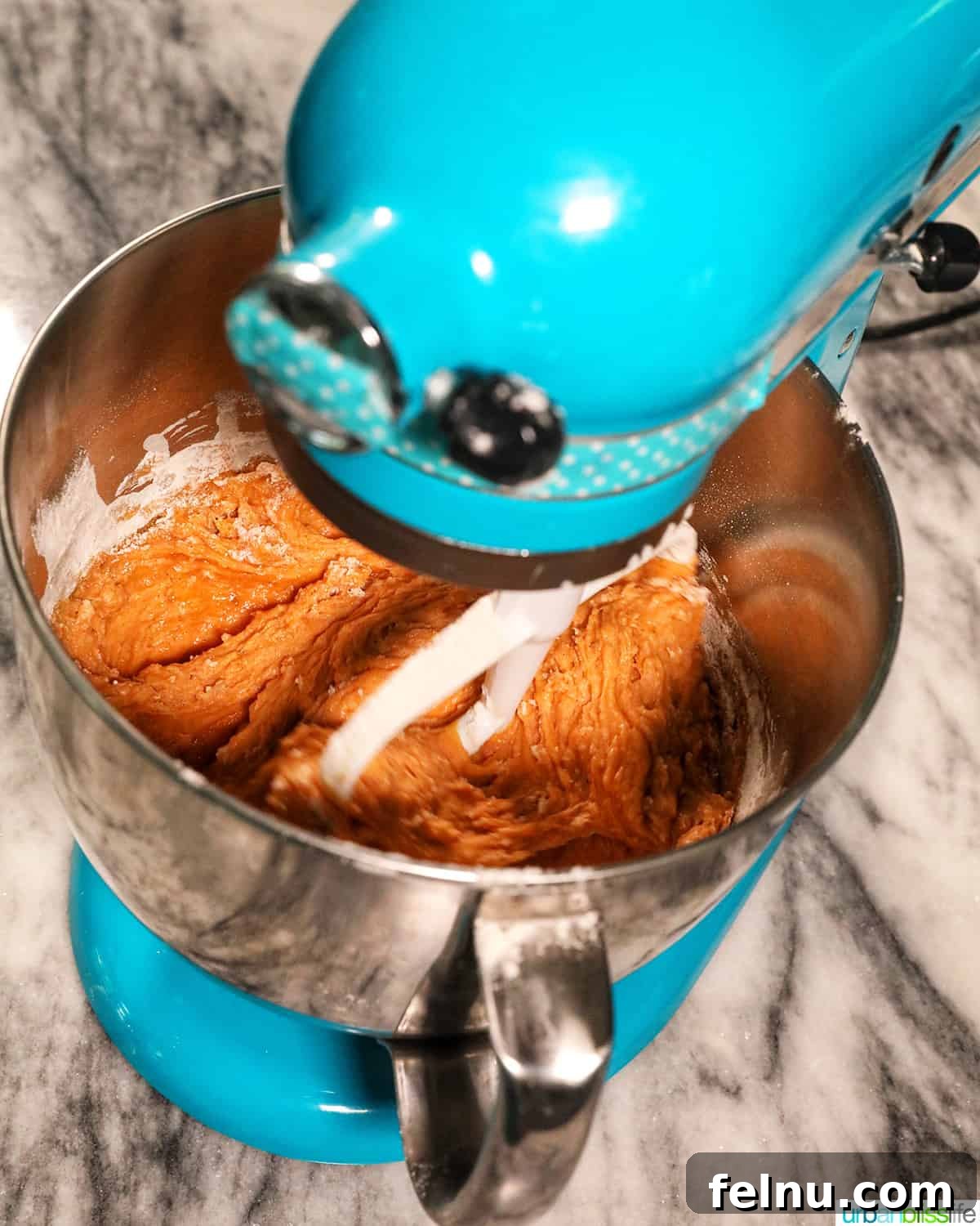 Pumpkin Banana Bliss Muffins 10 Blue stand mixer with pumpkin banana muffin batter inside.