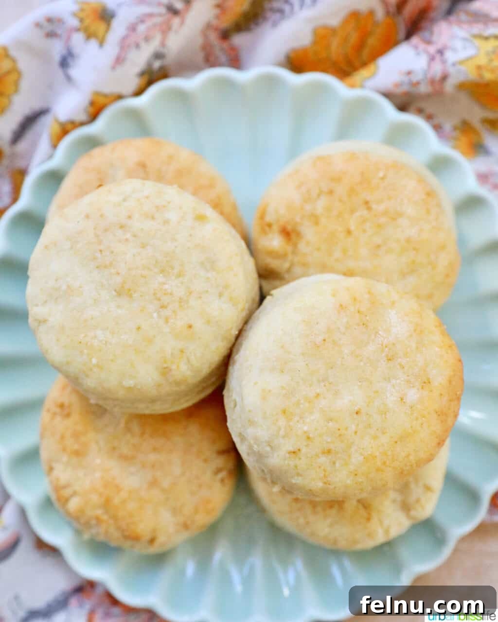 Fluffy Air Fryer Biscuits 15 air fryer biscuits stacked on a plate, overhead view.