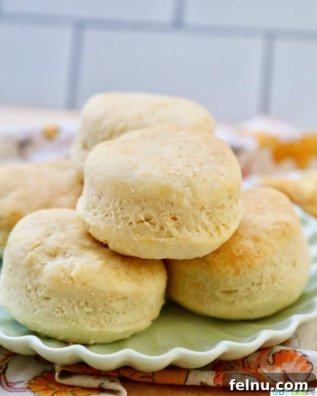 Fluffy Air Fryer Biscuits 16 air fryer biscuits stacked on a plate, side view.
